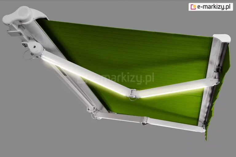 Przedstawiona na szarym tle markiza Adagio MOL z białą konstrukcją i zielonym poszyciem, wzbogacona o oświetlenie LED zainstalowane w ramionach. Jasna, neutralna barwa światła rozjaśnia kolor tkaniny.
