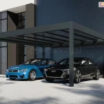 Carport ze szklanym dachem Spekta Glas w kolorze antracytowym ustawiony przy ścianie budynku wyłożonej grafitowymi panelami. Pod zadaszeniem na parkingu wyłożonym kostką brukową stoją dwa auta: niebieskie BMW oraz czarne Audi.