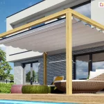 Pergola drewniana Koro przyścienna z dachem Silva osłaniają duże przeszklone drzwi tarasowe oraz meble tarasowe o ciekawym, okrągłym kształcie