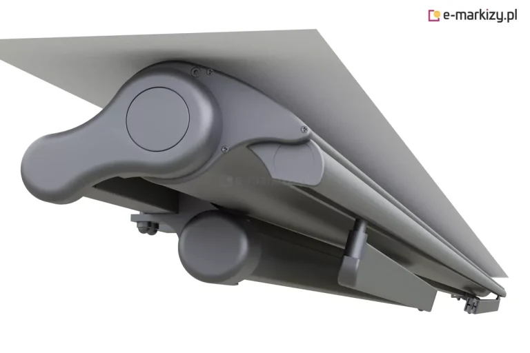 Zbliżenie na aluminiową kasetę markizy tarasowej w kolorze antracytowym, zamontowaną płasko do białej powierzchni sufitu lub wnęki. Zdjęcie przedstawia widok od dołu i z boku na mechanizm boczny markizy o opływowym, nowoczesnym kształcie. Widoczna jest szczelnie domknięta obudowa chroniąca poszycie, zintegrowany profil czołowy oraz złożone pod spodem ramiona przegubowe. Konstrukcja charakteryzuje się gładkim wykończeniem z widocznymi śrubami montażowymi i zaślepkami maskującymi punkty konstrukcyjne. Całość utrzymana jest w jednolitej, ciemnoszarej kolorystyce o matowej strukturze.