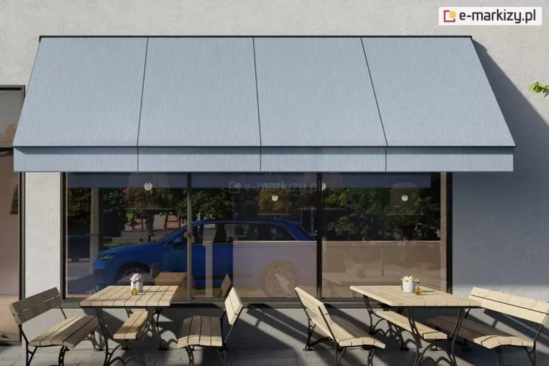 Wizualizacja przedstawiająca nowoczesną markizę sklepową z ramionami opadowymi, zamontowaną nad witryną lokalu usługowego lub restauracji. Markiza posiada gładkie poszycie w kolorze jasnoszarym, które jest w pełni rozwinięte i nachylone pod stałym kątem, zapewniając ochronę przeciwsłoneczną. Konstrukcja wsporcza, obejmująca ramiona boczne oraz belkę frontową, wykonana jest z profili aluminiowych w kolorze czarnym lub bardzo ciemnym grafitowym. Ramiona są przymocowane do jasnej, tynkowanej elewacji budynku po obu stronach dużego przeszklenia. W witrynie odbija się fragment ulicy oraz zaparkowany przy krawężniku niebieski samochód typu SUV. Przed lokalem, na brukowanym podłożu, ustawiono drewniane stoliki kawiarniane z dopasowanymi ławami o metalowych, ozdobnych stelażach. Na stolikach znajdują się drobne akcesoria, takie jak białe doniczki z roślinami. Scena ukazuje słoneczny dzień, co podkreślają wyraźne, ukośne cienie rzucane przez meble oraz krawędź markizy na elewację i chodnik.