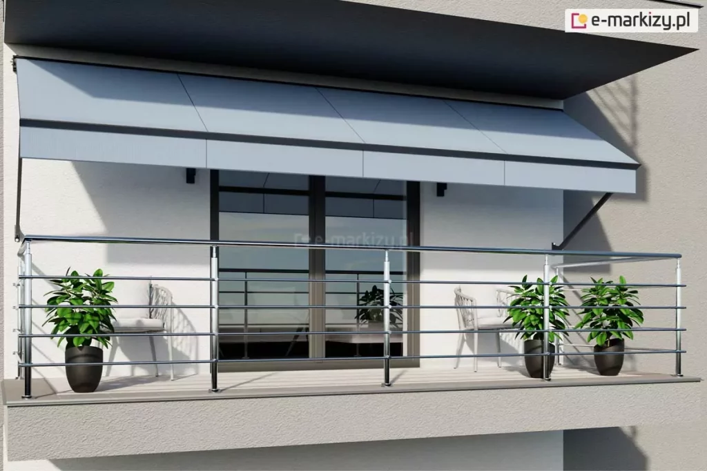 Zdjęcie przedstawia nowoczesny balkon wyposażony w rozłożystą markizę balkonowo-sklepową oraz balustradę ze stali nierdzewnej. Markiza w kolorze jasnoszarym jest zamontowana do białej elewacji budynku pod nawisem kolejnej kondygnacji. Materiał poszycia jest gładki i podzielony na cztery pionowe segmenty, a jej konstrukcja opiera się na bocznych ramionach, które stabilizują wysięg nad przestrzenią wypoczynkową. Poniżej markizy znajduje się okno balkonowe o ciemnych ramach, w którym odbija się otoczenie. Balustrada wykonana z błyszczącego metalu składa się z poziomych prętów zamocowanych do pionowych słupków, tworząc ażurową osłonę balkonu. Na podłodze balkonu, która wyłożona jest jasnymi płytkami, ustawiono trzy dekoracyjne rośliny w ciemnych donicach o zaokrąglonym kształcie. Rośliny mają gęste, zielone liście i są rozmieszczone symetrycznie – jedna po lewej stronie oraz dwie po prawej. W głębi, za balustradą, widoczne są dwa jasne krzesła ogrodowe o plecionej strukturze oparć. Całość aranżacji utrzymana jest w minimalistycznym i nowoczesnym stylu, z dominacją bieli, szarości i metalicznych akcentów.