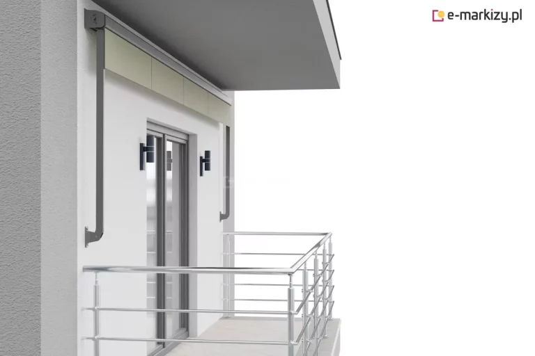 Wizualizacja przedstawia nowoczesną markizę balkonową w kasecie, zamontowaną nad przeszklonymi drzwiami prowadzącymi na balkon. Konstrukcja markizy składa się z ciemnoszarej, niemal czarnej kasety o prostokątnym przekroju, która jest przytwierdzona bezpośrednio do białej elewacji budynku, tuż pod zadaszeniem balkonu. Z kasety wysunięty jest niewielki fragment materiału w kolorze jasnobeżowym lub kremowym, zakończony prostym profilem obciążającym. Po bokach widoczne są dwa pionowe ramiona boczne o wygiętym kształcie, które mocowane są do ściany na wysokości środkowej części otworu drzwiowego. Ramiona te mają taki sam ciemnoszary kolor jak kaseta i służą do stabilizacji poszycia po jego rozwinięciu. Balkon posiada metalową, chromowaną balustradę o wysokim połysku, składającą się z poziomych relingów i pionowych słupków. Podłoga balkonu wyłożona jest jasnymi płytkami o delikatnym wzorze. Na ścianie budynku, po obu stronach przeszklonych drzwi, zamontowane są nowoczesne, minimalistyczne kinkiety zewnętrzne w kształcie czarnych tub, które kierują światło w górę i w dół. Elewacja budynku ma wyraźną strukturę tynku o jasnoszarym odcieniu. Całość kompozycji ukazana jest na białym, neutralnym tle, co podkreśla techniczne aspekty produktu i detale montażowe osłony przeciwsłonecznej.