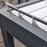 Zbliżenie narożnika konstrukcji pergoli tarasowej SB400 Selt z widocznym mechanizmem regulacji ustawienia paneli dachu tworzących wodoodporne, szczelne zadaszenie.
