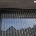 Moskitiera plisowana na oknie tarasowym zamocowana we wnęce pod klapą rewizyjną rolety zewnętrznej.