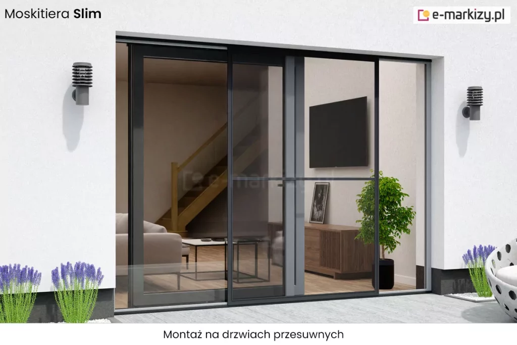 Zdjęcie prezentuje zastosowanie produktu moskitiera Slim na szerokich, dwuskrzydłowych drzwiach tarasowych o charakterze przesuwnym. Widok z zewnątrz budynku ukazuje nowoczesną bryłę o białej elewacji, na której zamontowano dwa stylowe, antracytowe kinkiety o żebrowanej konstrukcji, umieszczone symetrycznie po obu stronach wnęki okiennej. System moskitiera Slim składa się z cienkiej, niemal niewidocznej ramy w kolorze ciemnego grafitu, która przesuwa się na specjalnych szynach, chroniąc otwartą część przejścia przed insektami. Rama moskitiery posiada delikatną, poziomą poprzeczkę wzmacniającą konstrukcję, umieszczoną mniej więcej w połowie wysokości. Przez gęstą, czarną siatkę o wysokim stopniu transparentności doskonale widać luksusowe wnętrze salonu, w którym znajdują się drewniane schody z szklaną balustradą, jasna sofa, czarny telewizor na ścianie oraz niska szafka rtv z dekoracyjną rośliną doniczkową. Na tarasie, przed wejściem, po lewej stronie rosną kępy fioletowej lawendy w dekoracyjnym białym kruszywie, a po prawej widoczny jest fragment nowoczesnego, białego fotela ogrodowego o ażurowej strukturze. Całość kompozycji podkreśla techniczne atuty moskitiery Slim, takie jak minimalna grubość profili oraz możliwość integracji z dużymi przeszkleniami bez zaburzania estetyki budynku i widoku na zewnątrz. W dolnej części zdjęcia na białym pasku umieszczono napis "montaż na drzwiach przesuwnych".