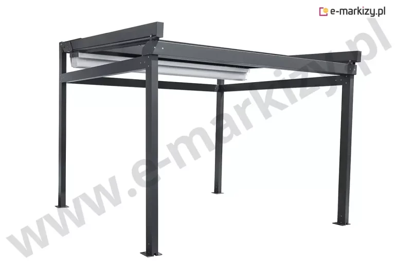 Nowoczesna pergola tarasowa Solid marki Aluprof o konstrukcji wolnostojącej wykonana z ekstrudowanego aluminium lakierowanego proszkowo na kolor ciemny grafit. Na zdjęciu widoczna jest stabilna rama składająca się z czterech pionowych słupów o kwadratowym przekroju, które u podstawy posiadają stopy montażowe z otworami na śruby. Górną część konstrukcji tworzą poziome belki obwodowe oraz prowadnice boczne, w których umieszczone jest ruchome zadaszenie tkaninowe. Poszycie w kolorze jasnoszarym lub białym jest w tej chwili częściowo zwinięte, tworząc charakterystyczne fałdy materiału podparte na poprzecznych profilach przeciwwietrznych. System rynien zintegrowany z ramą jest niewidoczny z zewnątrz, co podkreśla minimalistyczny i geometryczny design produktu. Konstrukcja charakteryzuje się brakiem widocznych połączeń śrubowych na głównych płaszczyznach profili, a górna szyna prowadząca wystaje nieznacznie poza obrys tylnych słupów, co sugeruje mechanizm przesuwny wysokiej klasy. Całość prezentuje się na białym, neutralnym tle, eksponując techniczne detale wykończenia oraz sztywność aluminiowych profili przystosowanych do zmiennych warunków atmosferycznych.