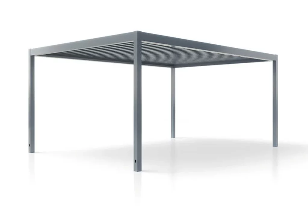 Nowoczesna pergola aluminiowa ogrodowa SB450 marki Aluprof w wersji wolnostojącej, zaprezentowana w trójwymiarowym ujęciu perspektywicznym na czystym, białym tle z delikatnym odbiciem konstrukcji na dolnej powierzchni. Całość konstrukcji nośnej, składająca się z czterech pionowych słupów podporowych o kwadratowym przekroju oraz prostej ramy dachowej, wykonana jest z aluminium lakierowanego proszkowo na jednolity, ciemnoszary kolor. Zadaszenie systemu opiera się na poziomych, obrotowych lamelach aluminiowych umieszczonych równolegle wewnątrz ramy głównej. Kadr ukazuje produkt od przodu pod wyraźnym kątem bocznym, co pozwala dokładnie zobrazować prostokątny kształt, stabilność konstrukcji oraz pustą przestrzeń użytkową pod zadaszeniem. W dolnej sekcji dwóch frontowych słupów widoczne są małe, pionowe, czarne otwory drenażowe, które służą do odprowadzania wody opadowej zbieranej przez system rynnowy ukryty w ramie.