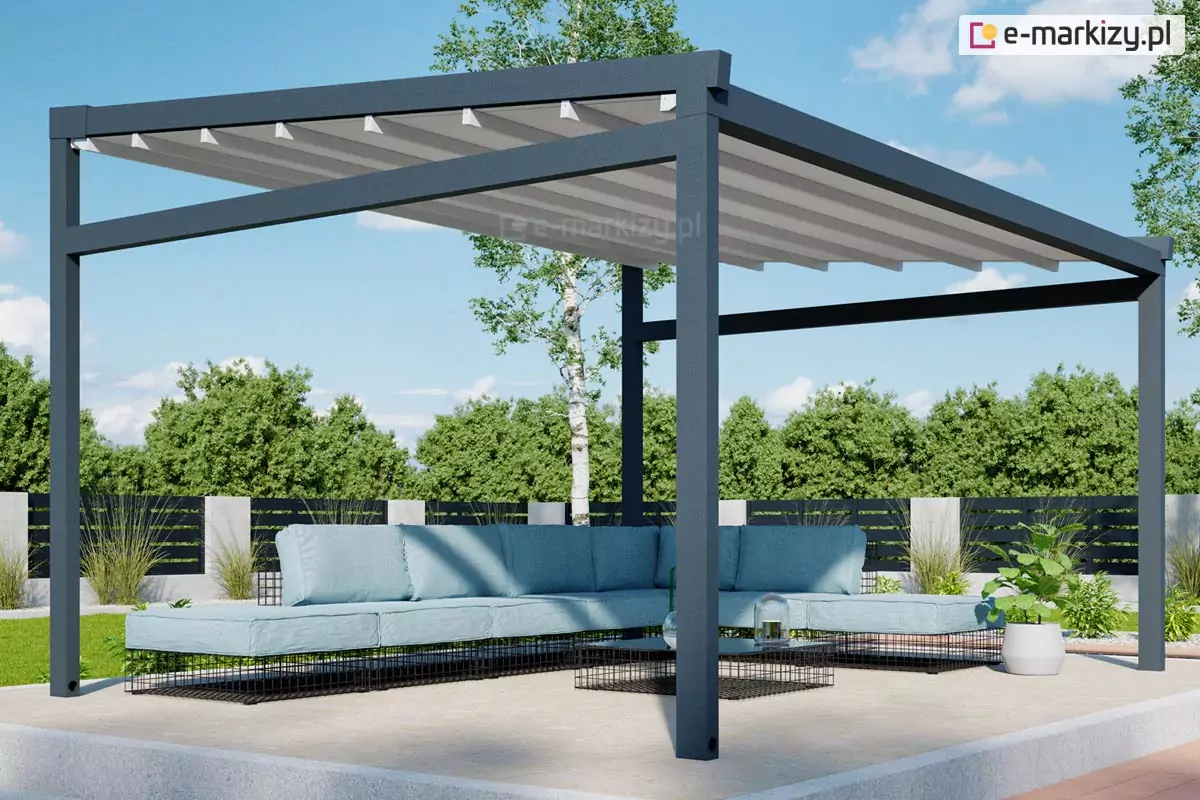 Wolnostojąca pergola ogrodowa Moderno o solidnej konstrukcji aluminiowej w kolorze ciemnego antracytu, wyposażona w rozsuwane zadaszenie tkaninowe w kolorze jasnoszarym. Materiał dachu układa się w charakterystyczne, estetyczne segmenty, wspierając się na poprzecznych profilach. Pod pergolą, na betonowym podeście, ustawiono nowoczesny narożnik ogrodowy z jasnoniebieskimi poduszkami na ażurowych, czarnych podstawach oraz minimalistyczny stolik kawowy. W tle widoczny jest zadbany ogród z zielonymi drzewami, trawnikiem oraz nowoczesnym ogrodzeniem panelowym, co podkreśla rekreacyjny charakter zabudowy.