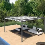 Pergola ogrodowa Dragon wolnostojąca na podeście drewnianym przy basenie zewnętrznym. Pod pergolą w cieniu ustawiony leżak oraz dwie kanapy z białymi poduszkami. Obok na słońcu ustawione dwa leżaki drewniane z białymi poduszkami. Dookoła przestrzeni drewnianego tarasu ogród z wysoką trawą i zielonymi drzewami.
