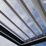 Konstrukcja pergoli tarasowej przyściennej SB400 z otwartym dachem z uchylonych lameli w pozycji skośnej oraz oświetleniem led na wewnętrznej stronie ramy