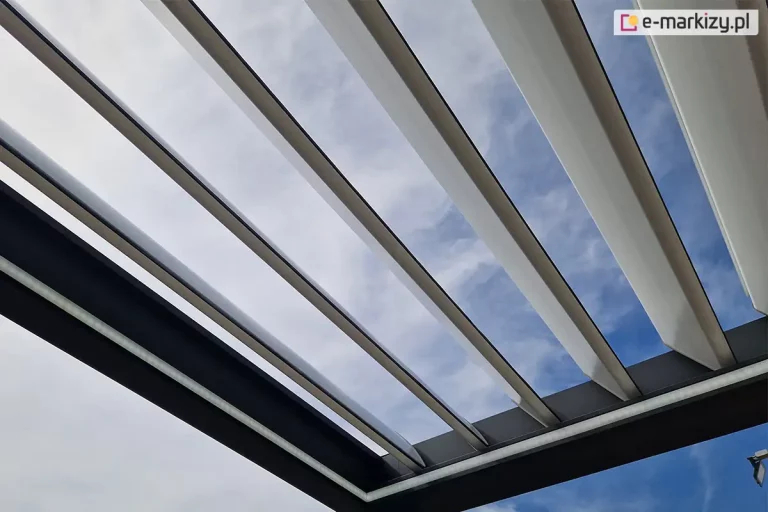 Konstrukcja pergoli tarasowej przyściennej SB400 z otwartym dachem z uchylonych lameli w pozycji skośnej oraz oświetleniem led na wewnętrznej stronie ramy