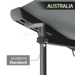 Zdjęcie prezentuje na białym tle sposób montażu teleskopowego wspornika, jakim jest podpora Standard, do konstrukcji osłony tarasowej Australia Aluprof. Na grafice widoczny jest fragment ciemnej belki frontowej oraz poszycia w kolorze antracytowym, do których za pomocą metalowego uchwytu przykręcona jest pionowa podpora w tym samym kolorze. W centralnej części wspornika znajduje się czarne pokrętło regulacyjne w kształcie gwiazdy, służące do blokowania wysokości rury teleskopowej. Po lewej stronie umieszczono szary boks informacyjny z napisem „podpora Standard”, połączony zieloną linią z punktem montażowym, natomiast w prawym górnym rogu widnieje nazwa modelu „AUSTRALIA”. Wizualizacja ma charakter techniczny i obrazuje praktyczne zastosowanie stabilizatora zwiększającego sztywność rozłożonej markizy.