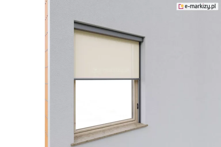 Refleksol 95 Aluprof w wersji z prowadnicami bocznymi mocowanymi za pomocą uchwytów stałych do drewnianej ramy okna. Tkanina zacieniająca w jasnym kolorze beżowym porusza się pionowo wzdłuż prowadnic z aluminium, zapewniając osłonę przeciwsłoneczną. Kaseta w kolorze antracytowym nie jest mocowana do podłoża, jest to system samonośny. Dolna część okna pozostaje odsłonięta, umożliwiając doświetlenie wnętrza, którego ściany pokryte zostały farbą w jasnoszarym kolorze.