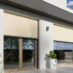 Wizualizacja architektoniczna nowoczesnego, białego budynku jednorodzinnego z dużymi przeszkleniami tarasowymi, na których zamontowano zewnętrzne refleksole Ziiip Box podtynkowe. Rolety posiadają poszycie w kolorze beżowym (kremowym) oraz ciemnoszare (antracytowe) profile konstrukcyjne. Na grafice widoczne są dwa duże okna tarasowe o drewnianych ramach. Lewa roleta jest rozwinięta do połowy wysokości szyby, natomiast prawa zasłania okno w nieco większym stopniu. System jest zamontowany na białej elewacji, pod ciemnym pasem gzymsu. Na ścianach pomiędzy oknami zainstalowano nowoczesne, szare kinkiety zewnętrzne o kwadratowym kształcie. Przed oknami znajduje się taras wyłożony jasnoszarymi płytami gresowymi. W centralnej części stoi biała, dekoracyjna donica w kształcie figurki z rośliną, a w tle, za przeszkleniem, widoczne są białe meble ogrodowe. Całość przedstawiona jest w pełnym świetle dziennym, podkreślając funkcję ochrony przed słońcem przy jednoczesnym zachowaniu estetyki elewacji.