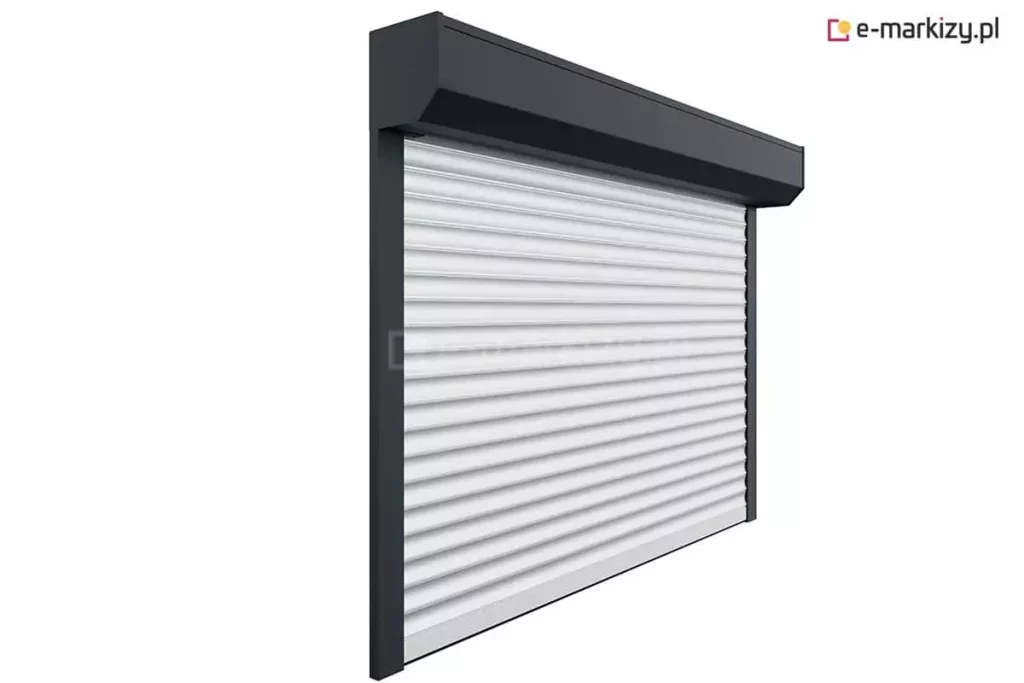 Zdjęcie przedstawia roletę zewnętrzną wykonaną na wymiar, dopasowaną idealnie do wnęki okiennej. Widoczna aluminiowa kaseta w wersji natynkowej mieści zwijany pancerz rolety, który porusza się w bocznych prowadnicach. System zapewnia estetyczne wykończenie elewacji, a także ochronę przeciwsłoneczną, termiczną i prywatność. Roleta może być wyposażona w napęd ręczny lub elektryczny, w zależności od preferencji użytkownika.