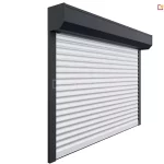Zdjęcie przedstawia roletę zewnętrzną wykonaną na wymiar, dopasowaną idealnie do wnęki okiennej. Widoczna aluminiowa kaseta w wersji natynkowej mieści zwijany pancerz rolety, który porusza się w bocznych prowadnicach. System zapewnia estetyczne wykończenie elewacji, a także ochronę przeciwsłoneczną, termiczną i prywatność. Roleta może być wyposażona w napęd ręczny lub elektryczny, w zależności od preferencji użytkownika.