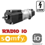 Silnik do żaluzji fasadowych Somfy J4 io z funkcją HomeControl – rozwiązanie do automatyzacji sterowania żaluzjami. Na zdjęciu przedstawiono produkt z widocznymi detalami konstrukcyjnymi oraz oznaczeniami technicznymi na białym tle. Idealny do inteligentnych domów. W prawym górnym rogu umieszczono w czarnej ramce o zaokrąglonych rogach symbol błyskawicy a pod nim napis "230V" wykonane w kolorze czarnym. Pod silnikiem z lewej strony logo somfy a nad nim napis czerwoną czcionką "RADIO IO". Po prawej w dolnym rogu logo "IO homecontrol".