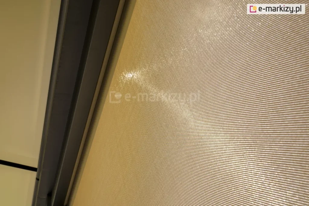 Zbliżenie tkaniny refleksola w kolorze kremowym, która przepuszcza około 5 procent promieniowania słonecznego, zapewniając jednocześnie cień i ochronę przed słońcem oraz odpowiednią ilość światła.
