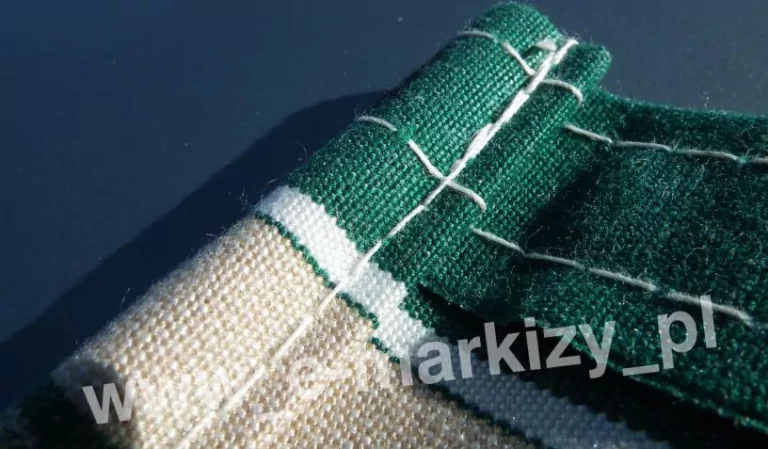 Zbliżenie kieszeni w poszyciu do markizy wykonanym z tkaniny akrylowej w pasy zielone, białe i beżowe, poszycie zszywane jest mocnymi nićmi o białym kolorze