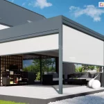 Wizualizacja nowoczesnej, dwumodułowej pergoli tarasowej zamontowanej do elewacji budynku z dachem krytym ciemną blachą. Konstrukcja pergoli wykonana jest z profili aluminiowych w kolorze ciemnego antracytu i wyposażona w system pełnej zabudowy bocznej oraz frontowej typu Refleksol. Na grafice widoczne są trzy białe rolety ekranowe: jedna szeroka na boku konstrukcji oraz dwie mniejsze na froncie, z których każda jest opuszczona do połowy wysokości słupów wsporczych. Pod pergolą znajduje się jasny taras wyłożony dużymi płytami, na którym zaaranżowano strefę wypoczynkową oraz letnią kuchnię. Wyposażenie obejmuje ciemny zestaw mebli ogrodowych z jasnymi poduszkami, nowoczesny stolik kawowy oraz czarną, mobilną wyspę kuchenną z grillem. Dekorację przestrzeni stanowią duże, białe kule świetlne ustawione bezpośrednio na podłożu oraz podłużna donica z intensywnie różowymi kwiatami po prawej stronie. W tle widać fragmenty ogrodu oraz sąsiednią zabudowę pod pogodnym, błękitnym niebem. Zdjęcie szczegółowo prezentuje funkcjonalność osłon pionowych w dużych, wielomodułowych systemach zadaszeń.