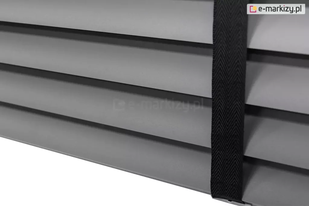 Żaluzja aluminiowa z lamelami 50 mm w kolorze szarym o matowym wykończeniu, której elegancję podkreśla drabinka taśmowa w kolorze czarnym.