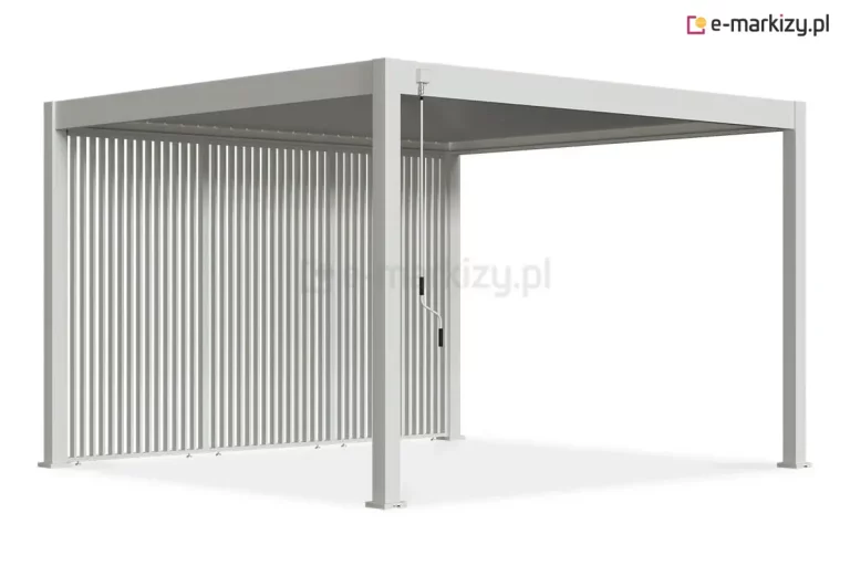 Wizualizacja przedstawia białą pergolę tarasową Marlo o aluminiowej konstrukcji, wyposażoną w system bocznej zabudowy z pionowych paneli żaluzjowych. Wszystkie elementy strukturalne, w tym cztery narożne słupy o kwadratowym przekroju oraz rama dachu, wykończone są w białym kolorze. Lewy bok pergoli wypełniają trzy stałe moduły składające się z gęsto rozmieszczonych, pionowych lamelek, które tworzą estetyczną barierę zapewniającą prywatność. Na przednim słupie, przy górnej belce, zamontowana jest korba ręczna z długim białym drążkiem i czarnymi uchwytami, przeznaczona do sterowania mechanizmem zadaszenia. U podstawy paneli widoczne są stopki montażowe. Całość zaprezentowana jest na białym tle, co podkreśla nowoczesny, minimalistyczny design produktu.