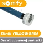 Zdjęcie prezentuje silnik Somfy przeznaczony do automatyzacji osłon, takich jak markiza Corsica. Na białym tle widoczny jest fragment niebieskiego silnika rurowego zakończonego jasną głowicą z otworami montażowymi. W górnej części grafiki umieszczono pomarańczowy logotyp producenta, natomiast dolną część zajmują dwa pasy informacyjne. Górny, żółty pas zawiera napis „Silnik YELLOW OREA”, a dolny, szary pas informuje, że jest to model „Bez wbudowanej centralki”. Całość ma charakter produktowy i techniczny, ułatwiający identyfikację konkretnego modelu napędu elektrycznego.
