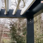 Gotowe zadaszenie tarasu w kontrastowych kolorach na tle jesiennego ogrodu