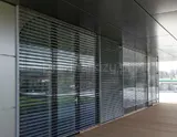 Żaluzje fasadowe na ścianie budynku z lamelami otwartymi