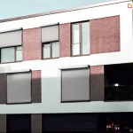 Rolety zamontowane na elewacji budynku mieszkalnego szczelnie zasłaniają okna przed warunkami atmosferycznymi