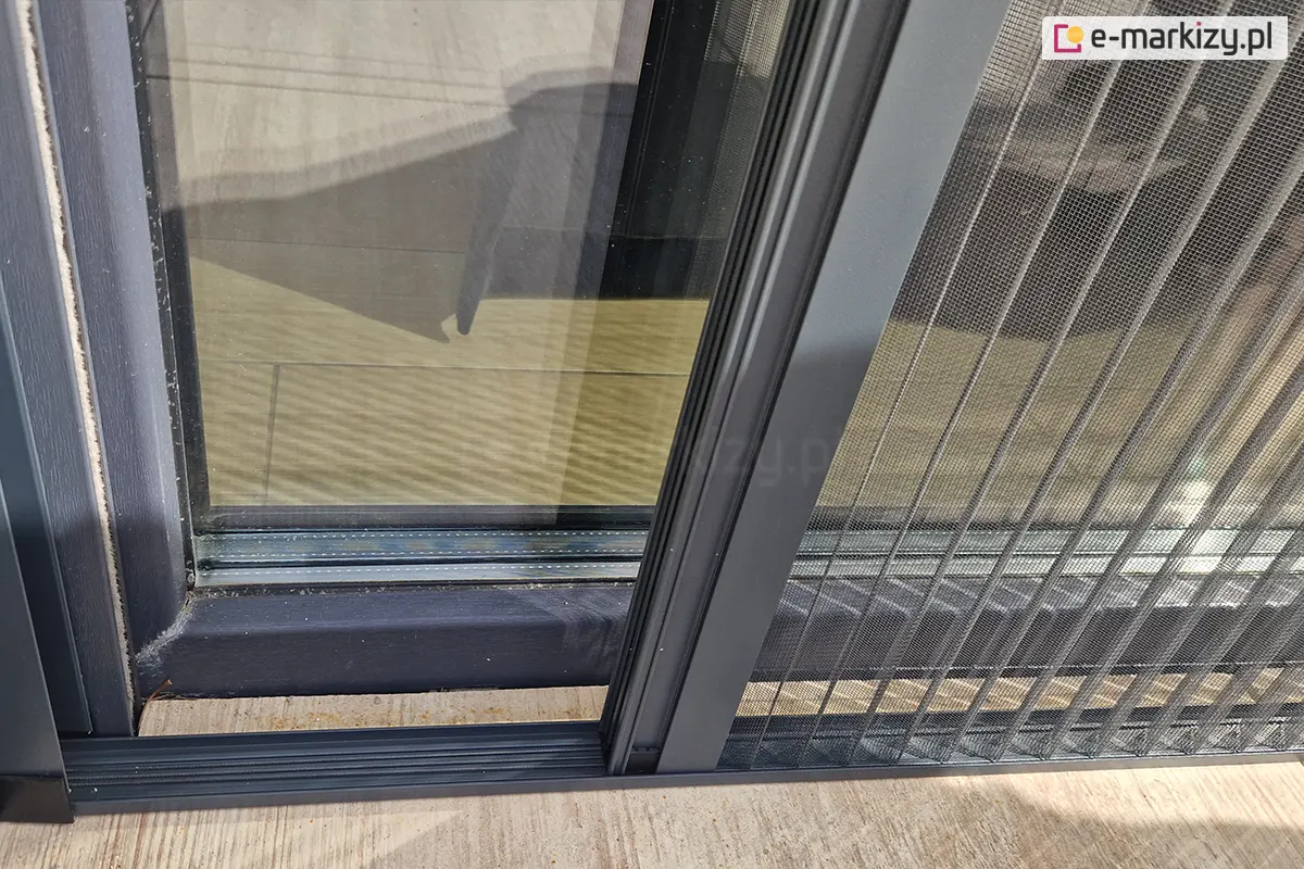 Aluminiowa konstrukcja moskitiery montowana blisko drzwi we wnęce drzwiowej