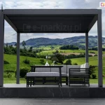 Antracytowa pergola aluminiowa SB350 selt z zamkniętym dachem lamelowym i automatyką bezprzewodową Blebox nad podestem z marmuru, taras z widokiem na góry oraz zielone wzgórza z roślinnością