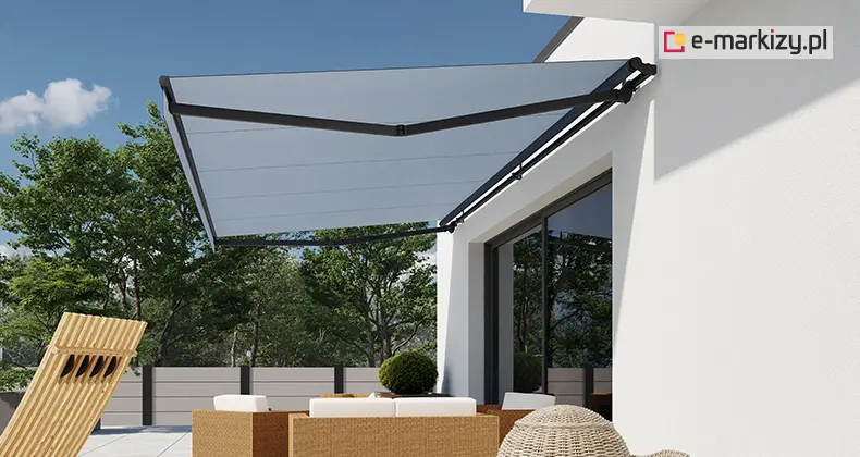 Markiza Australia Selt zamontowana na ścianie nowoczesnego domu, z wysuniętym szarym poszyciem i solidnym czarnym stelażem, zapewniająca cień nad tarasem z meblami wypoczynkowymi.