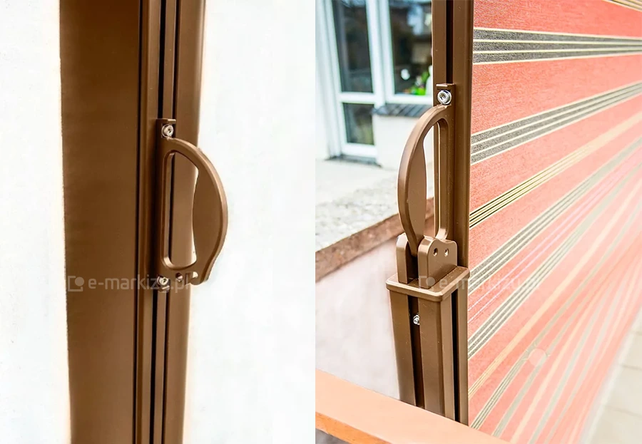 Zbliżenie na uchwyt bocznej markizy Bora Selt zaczepiony do słupka aluminiowego w kolorze brązowym, z widoczną tkaniną w czerwone pasy.
