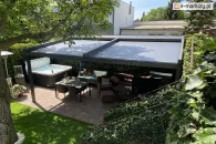 Nowoczesna pergola Square z grafitową aluminiową konstrukcją wspartą na 4 podporach i szarą tkaniną przeciwsłoneczną anty UV, zamontowana w ogrodzie nad tarasem z jacuzzi, stołem jadalnianym i kompletem wypoczynkowym, zapewniająca skuteczną ochronę przed słońcem.