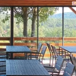 Przesuwne drzwi szklane Sotro w restauracji z panoramicznym widokiem na las i góry – przestrzeń z wytrzymałą ramową zabudową ze szkła