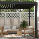 Stylowa pergola aluminiowa Gloria ustawiona na czterech podporach przy elewacji budynku, z dachem z obracanych lameli, które chronią przed słońcem i deszczem.