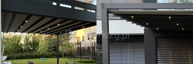 Pergola tarasowa Square Flat z podświetleniem punktowym LED zamontowanym w segmentach dachowych. Konstrukcja aluminiowa w odcieniu antracytu, dach z tkaniny w pełni rozwinięty. W tle nowoczesny budynek mieszkalny z dużymi przeszkleniami i żaluzjami fasadowymi.