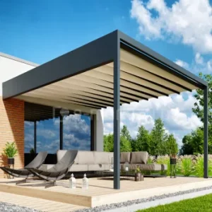 Pergola Luxury montowana do ściany, z tkaninowym dachem przesuwanym w prowadnicach i zintegrowaną rynną boczną odprowadzającą wodę, zadasza nowoczesny taras z leżakami i przestronną sofą ogrodową. Solidna, antracytowa konstrukcja podkreśla luksusowy charakter pergoli, a całość otacza zadbany ogród.