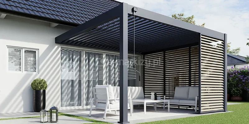 Pergola Rubio Soft z bocznymi panelami żaluzjowymi tworzy półzamkniętą, prywatną przestrzeń tarasową z estetyczną ochroną przed słońcem i wiatrem. Połączenie antracytowej konstrukcji z drewnianymi lamelami panelu dodaje tarasowi nowoczesnego, ciepłego charakteru. Wnętrze pergoli uzupełniają jasne meble wypoczynkowe ustawione przy dużych przeszklonych drzwiach.