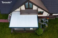 Zbliżenie na konstrukcję bioklimatycznego dachu z aluminiowymi lamelami obracanymi elektrycznie, ukazujące precyzję wykonania, szczelność i nowoczesny charakter pergoli przyściennej zamontowanej nad tarasem.