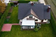 Pergola Tarasola Essential zamontowana na przestronnym tarasie domu jednorodzinnego z widokiem na ogród i zadbane rabaty