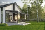 Tarasowa pergola rzymska Elegancy Tarasola z przesuwną zabudową szklaną otacza przestrzeń relaksu z dużą sofą i stolikiem. Konstrukcja stoi na podwyższonej platformie tarasowej, otulona zielenią drzew i otwartą przestrzenią ogrodu.