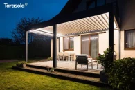 Lamelowa konstrukcja pergoli Tarasola Essential w dużym wymiarze 6x3 metrów tworzy przestronny salon na świeżym powietrzu z wyraźnie zaznaczonym podziałem na strefę jadalnianą i wypoczynkową. Otoczenie stanowi równy trawnik i naturalne żywopłoty, które dodają lekkości całej aranżacji.