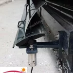 Widok od boku na żaluzję fasadową C80L Selt w kolorze grafitowym z prowadnicą linkową zamocowaną do uchwytu modułowego pojedynczego. W wystającej części zamocowany obciążnik z linką w kolorze czarnym, która przechodzi przez owalne otwory wykonane przy krawędzi lameli.
